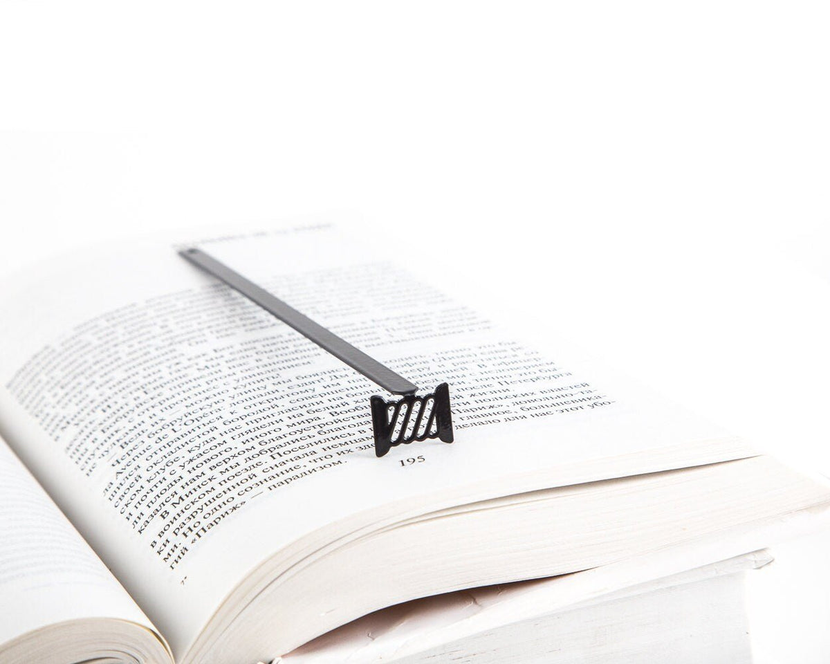 Spool of Thread metal bookmark resting on the pages of an open book