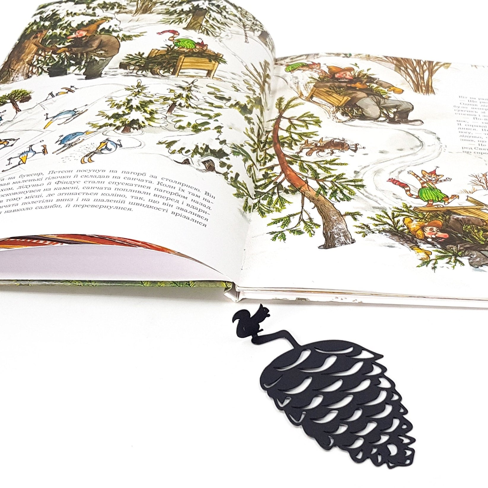 Squirrel and a Pinecone metal bookmark on an illustrated page