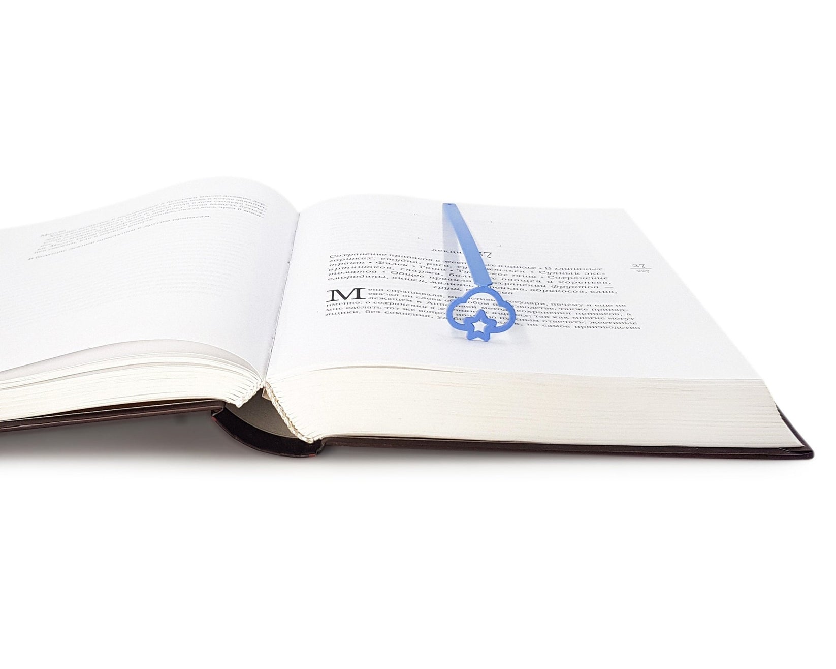Star Cloud metal bookmark in blue marking a page in an open book