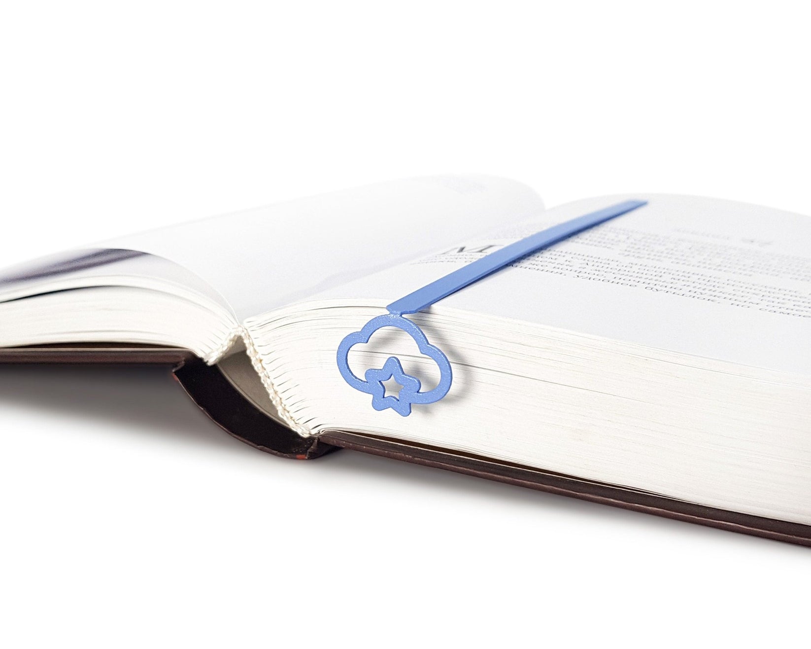 Star Cloud metal bookmark in blue lying across the pages of an open book