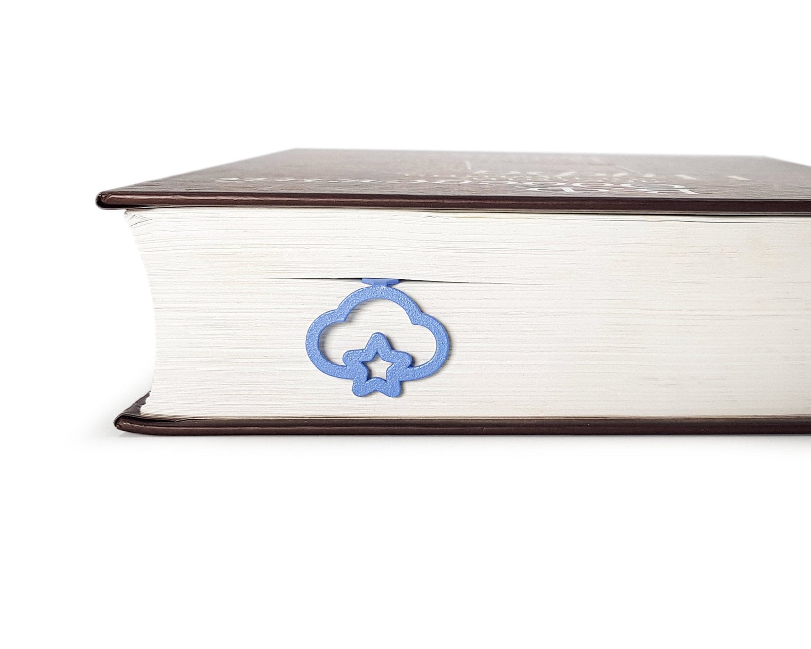 Star Cloud metal bookmark in blue seen from the edge of a closed book