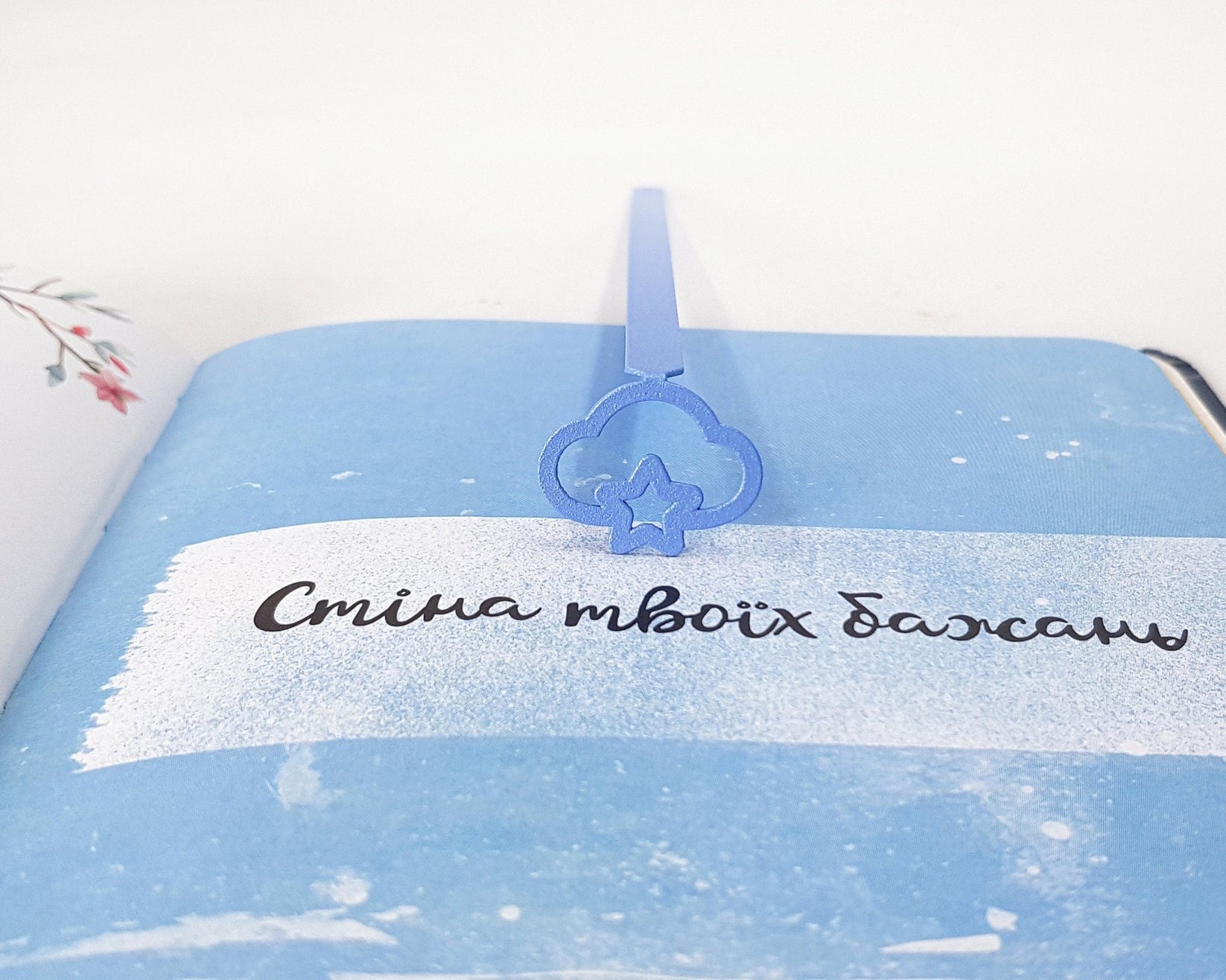 Star Cloud metal bookmark in blue against a coloured backdrop