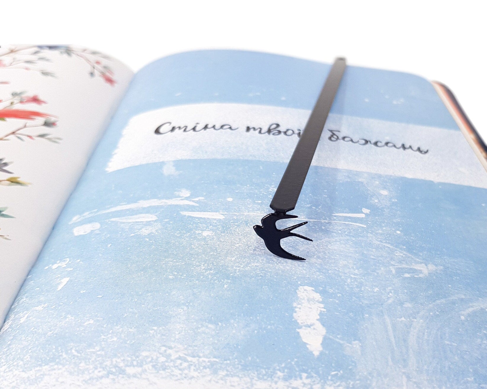 Swallow metal bookmark shot on a coloured surface