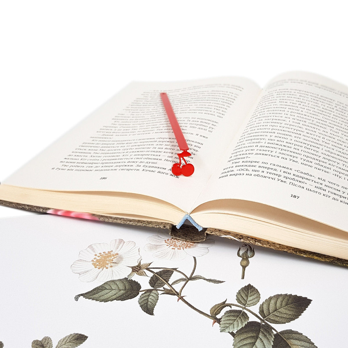 Sweet Cherries metal bookmark in red resting on the pages of an open book