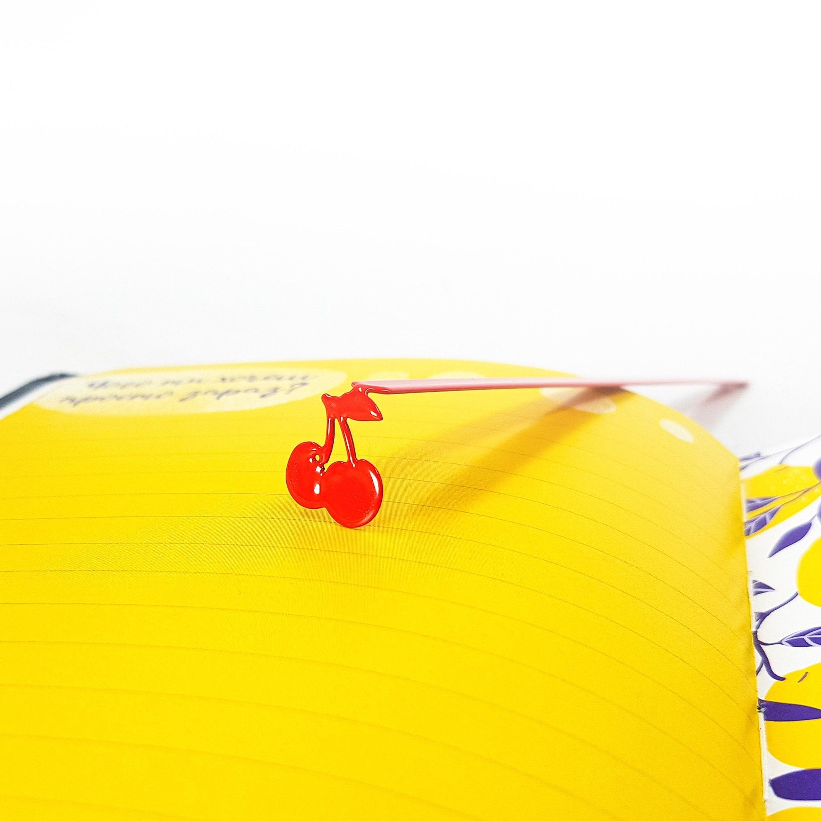 Sweet Cherries metal bookmark in red on a coloured background