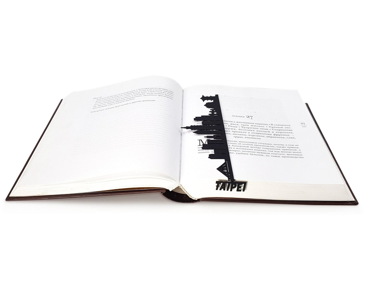 Taipei metal bookmark lying across the pages of an open book