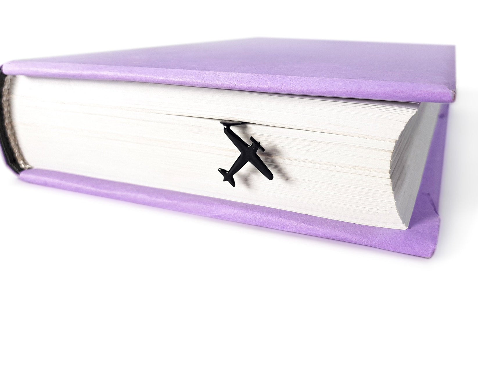 Take a Book Will Fly metal bookmark seen from the edge of a closed book