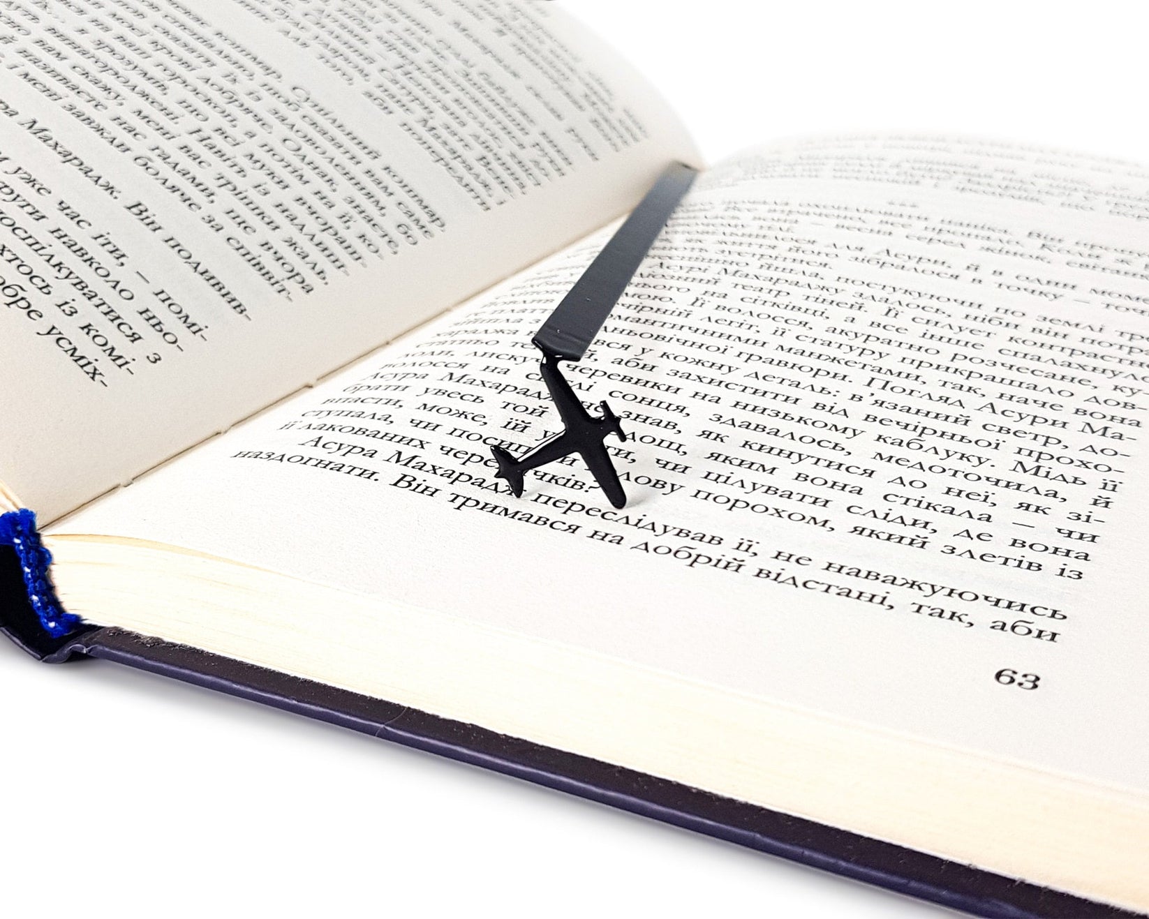 Take a Book Will Fly metal bookmark resting on the pages of an open book