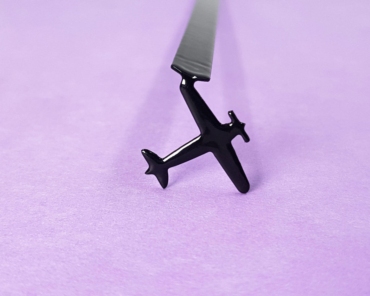 Take a Book Will Fly metal bookmark against a coloured backdrop