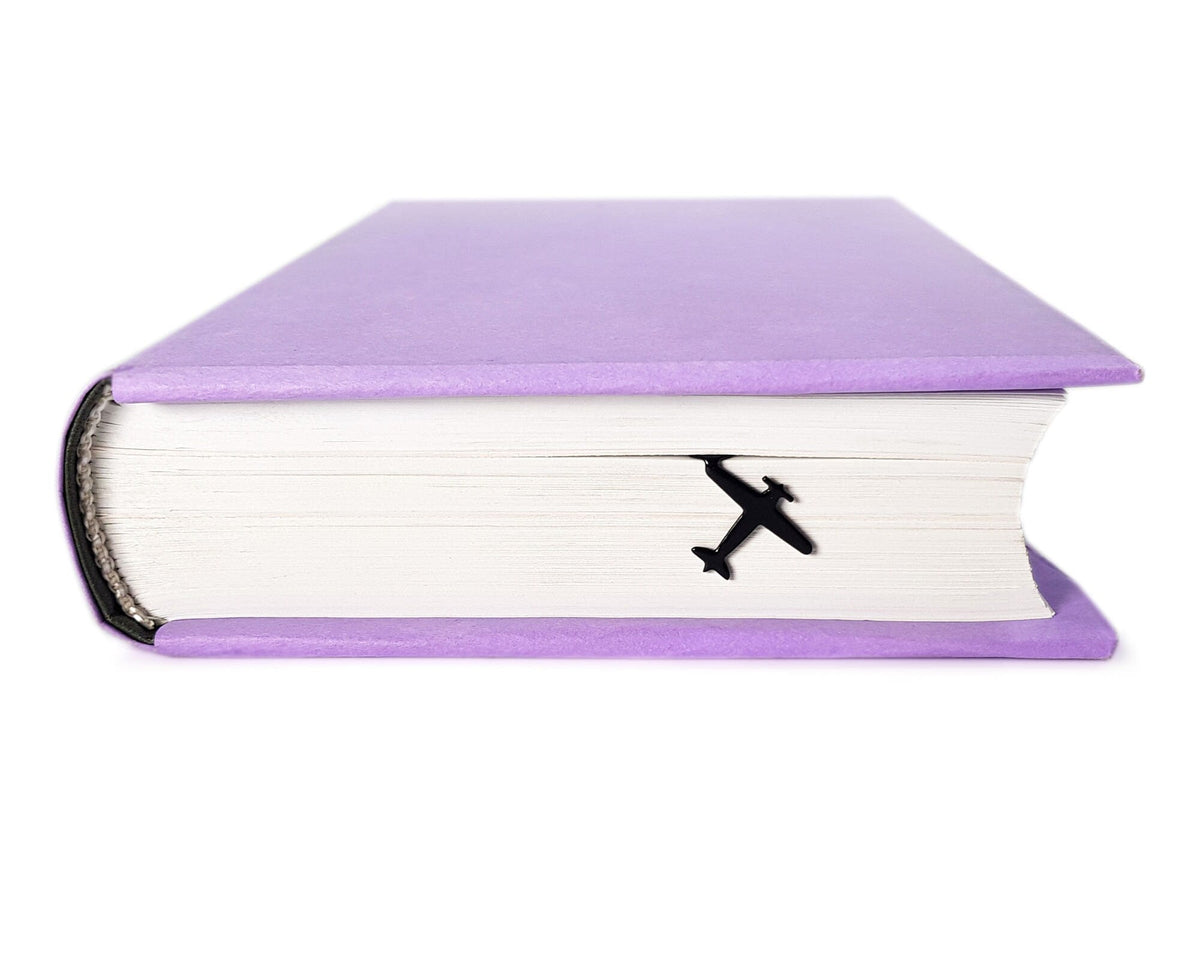 Take a Book Will Fly metal bookmark in a closed book, only its top showing above the pages
