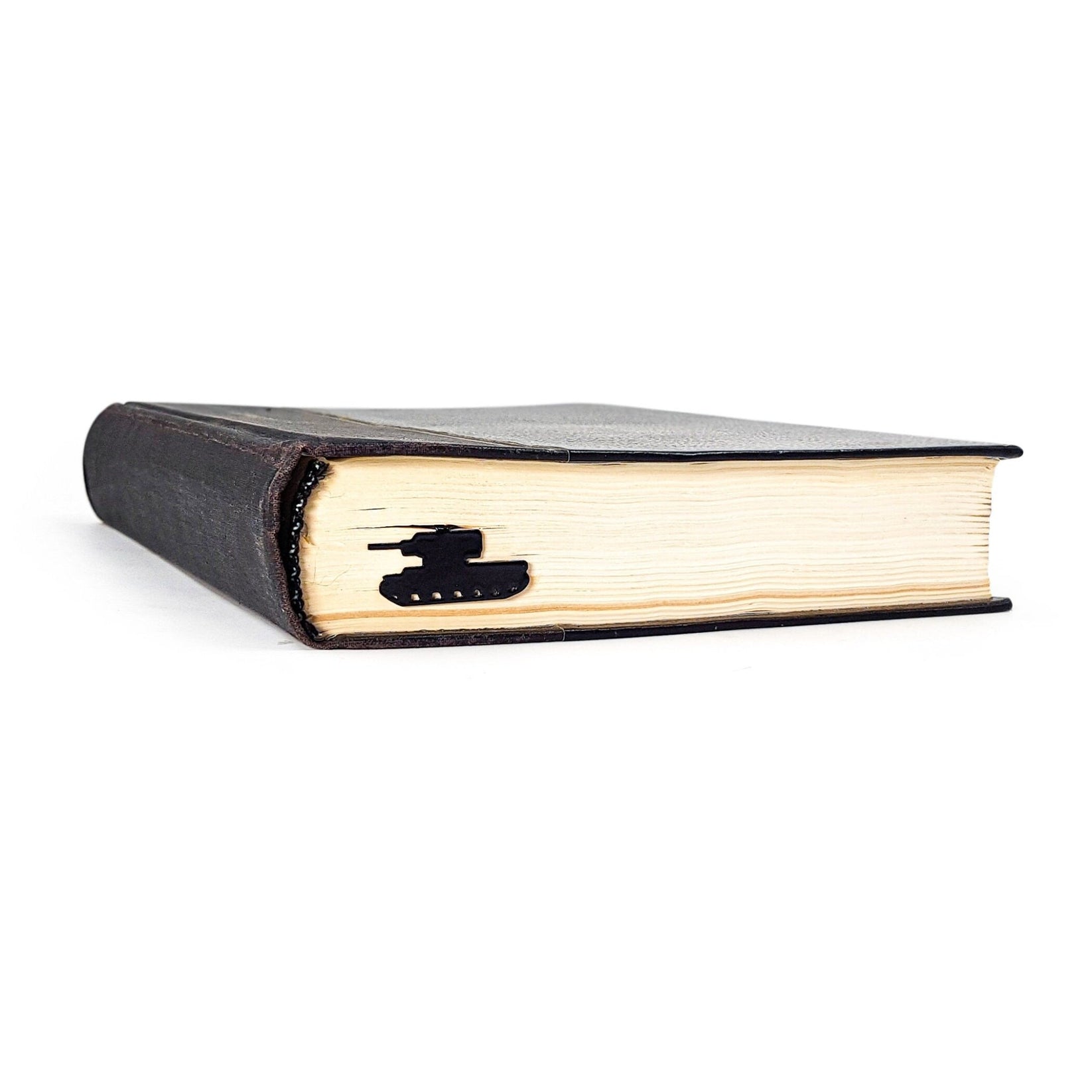 Tank metal bookmark clipped in a closed book, viewed from the side