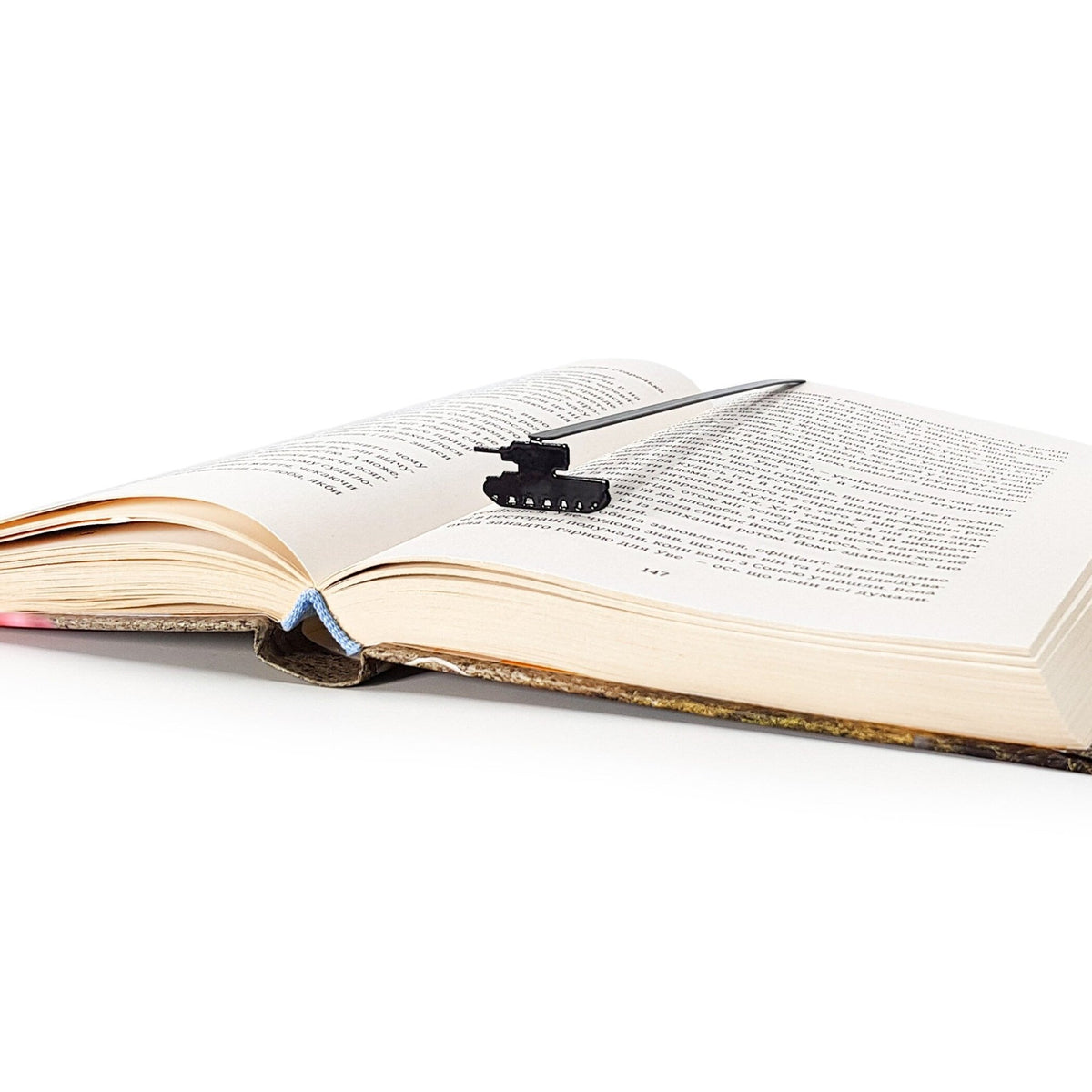 Tank metal bookmark resting on the pages of an open book