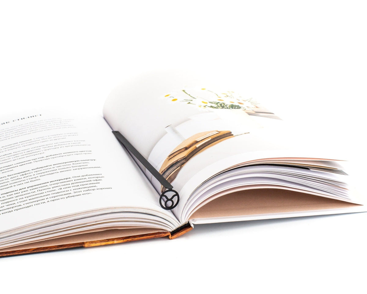Taurus metal bookmark resting on the pages of an open book