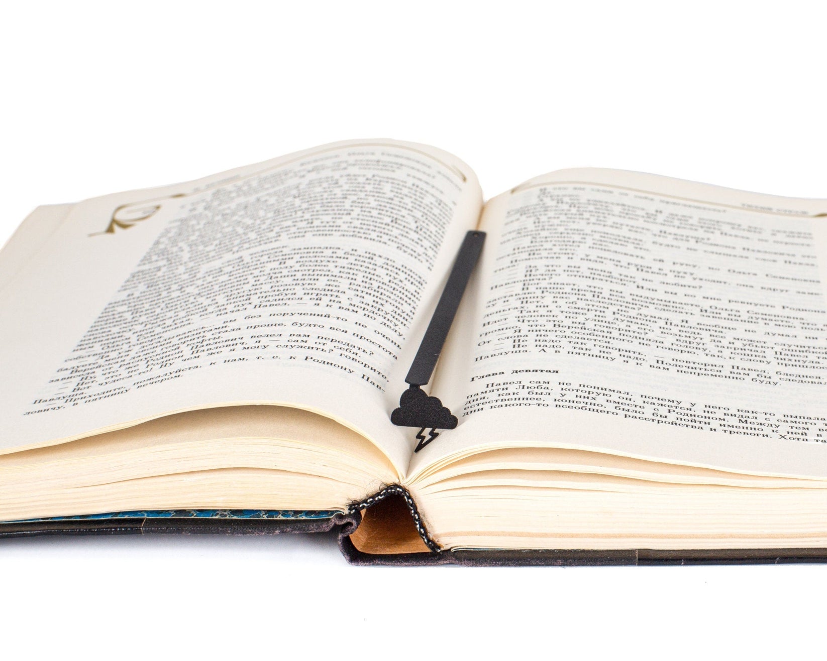 Thunderstorm metal bookmark resting on the pages of an open book