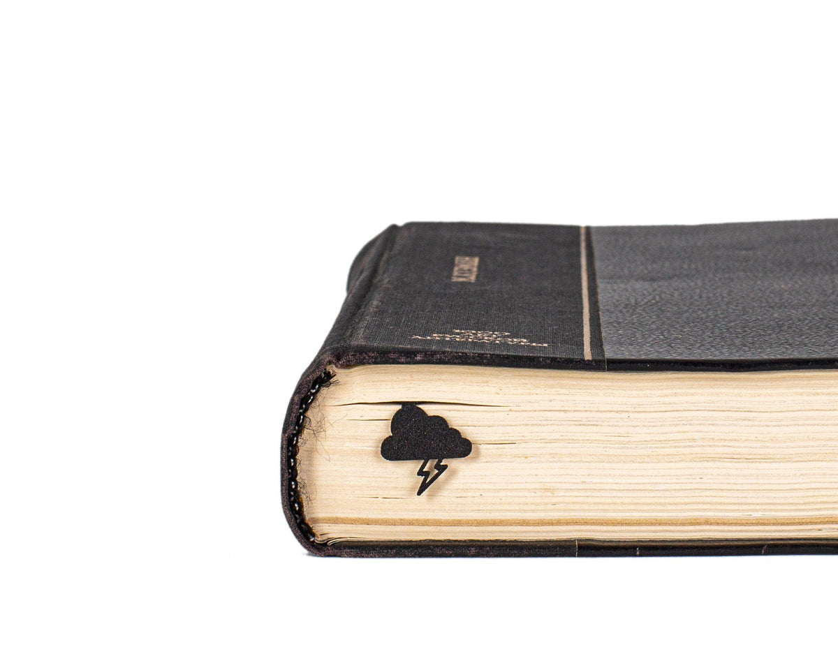 Thunderstorm metal bookmark seen from the edge of a closed book