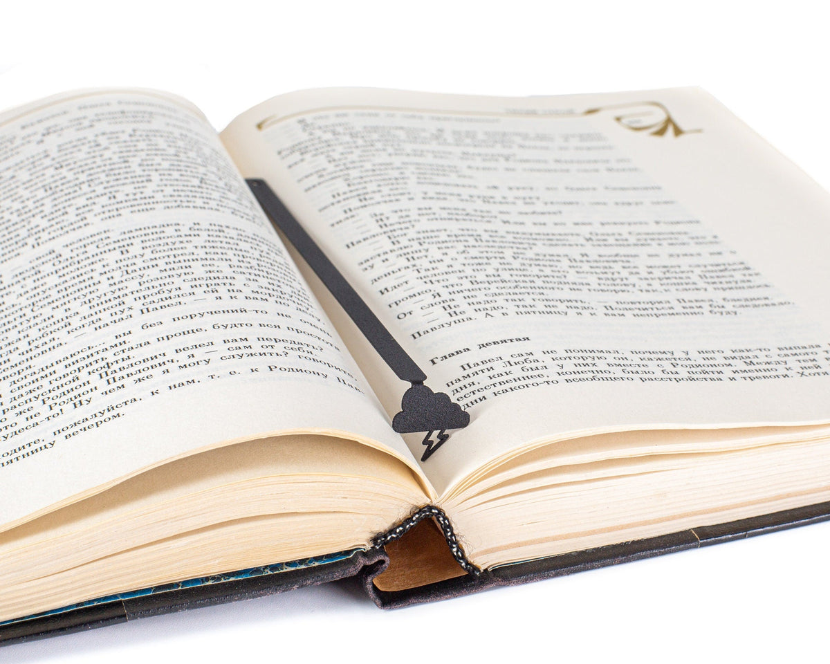 Thunderstorm metal bookmark marking a page in an open book