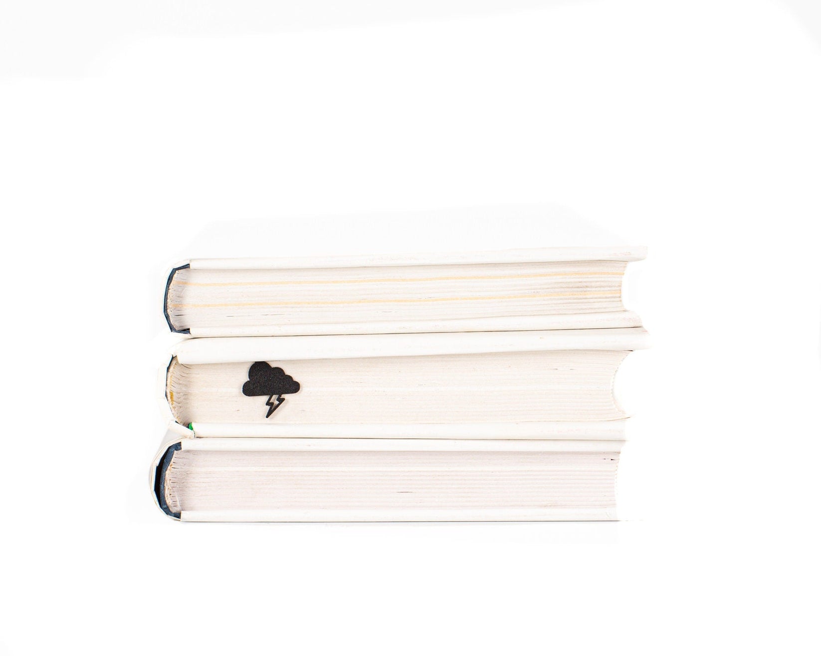 Thunderstorm metal bookmark lying on a stack of white books