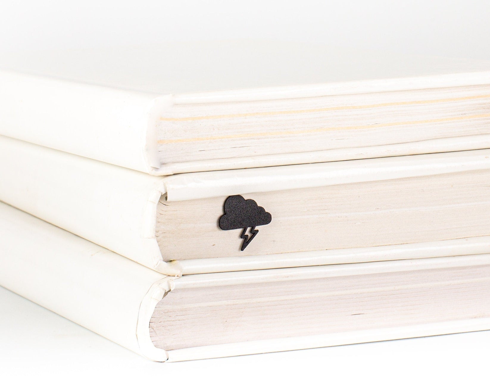 Thunderstorm metal bookmark shown with a stack of books