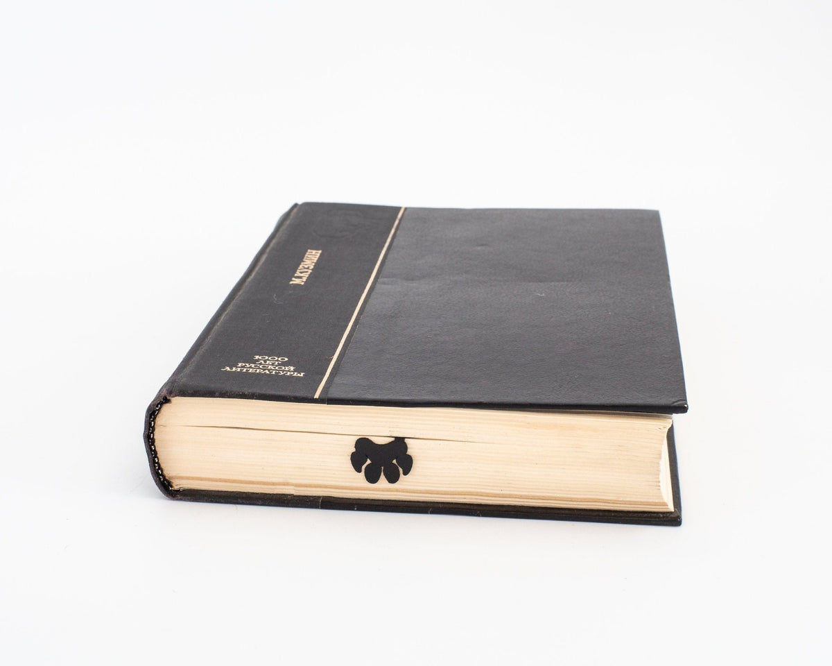 Tiger Head metal bookmark seen from the edge of a closed book