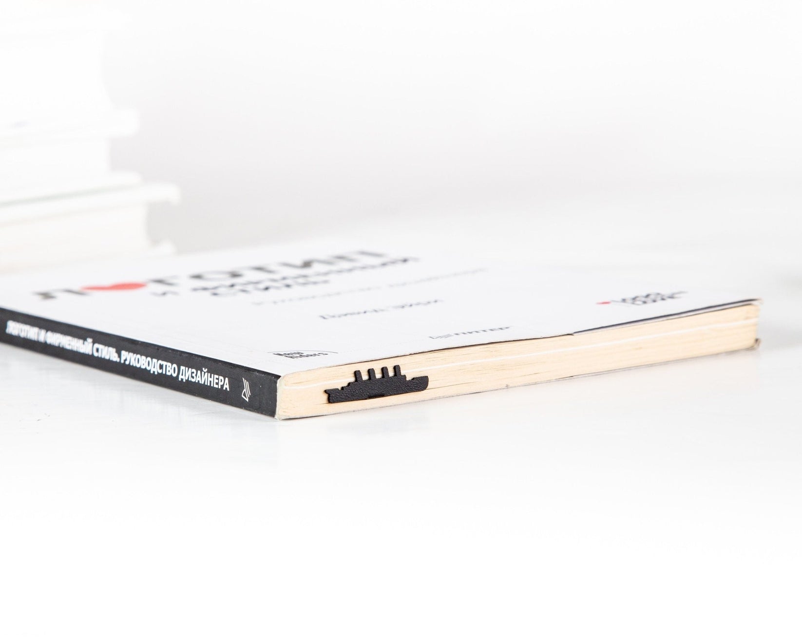 Titanic metal bookmark in a closed book, only its top showing above the pages