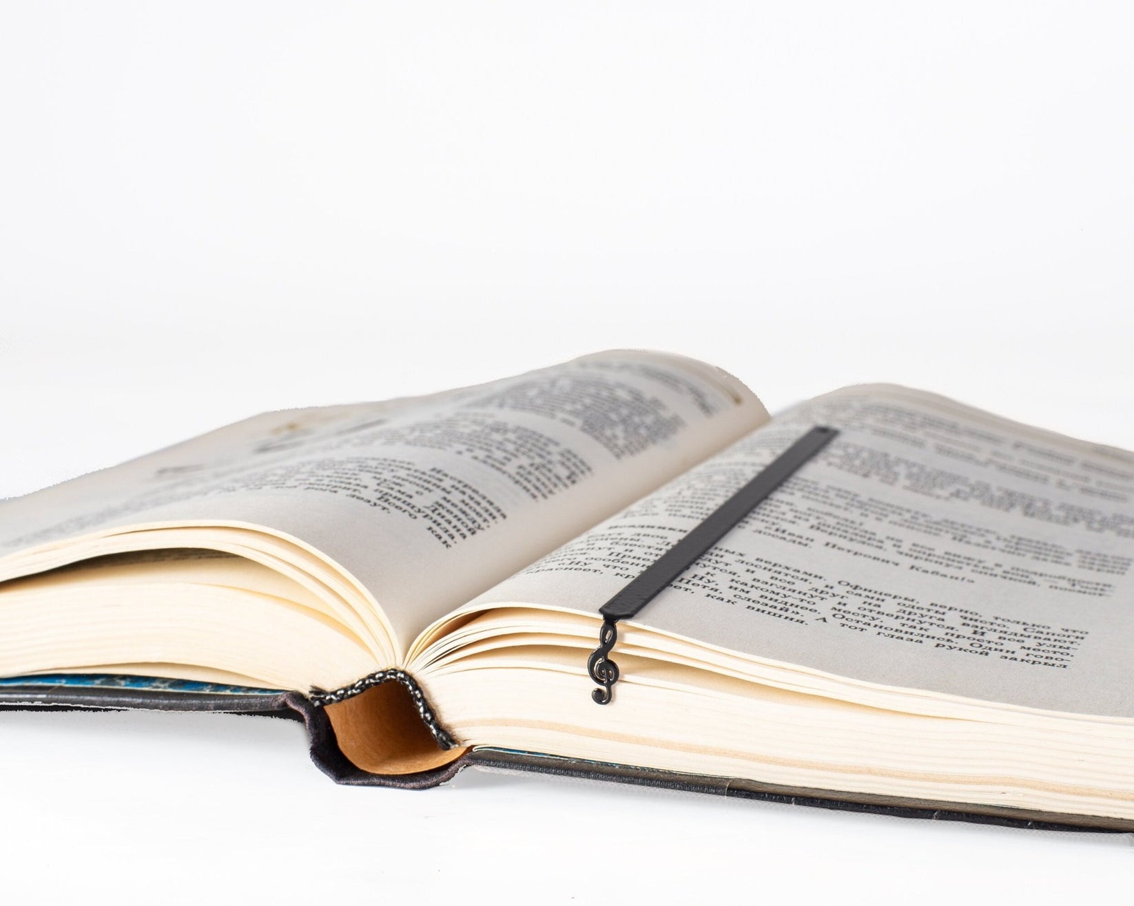 Treble Clef metal bookmark resting on the pages of an open book