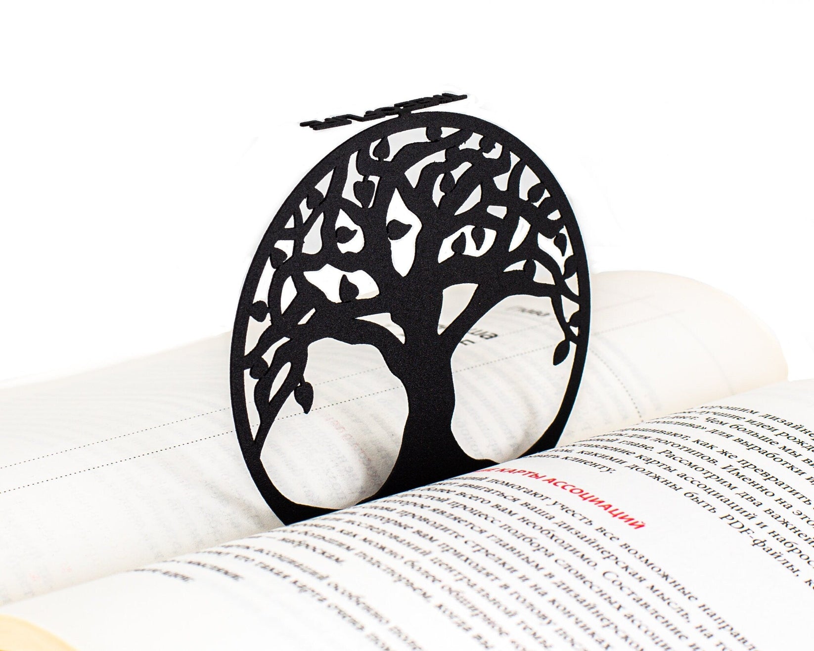 Tree of Life metal bookmark resting on the pages of an open book