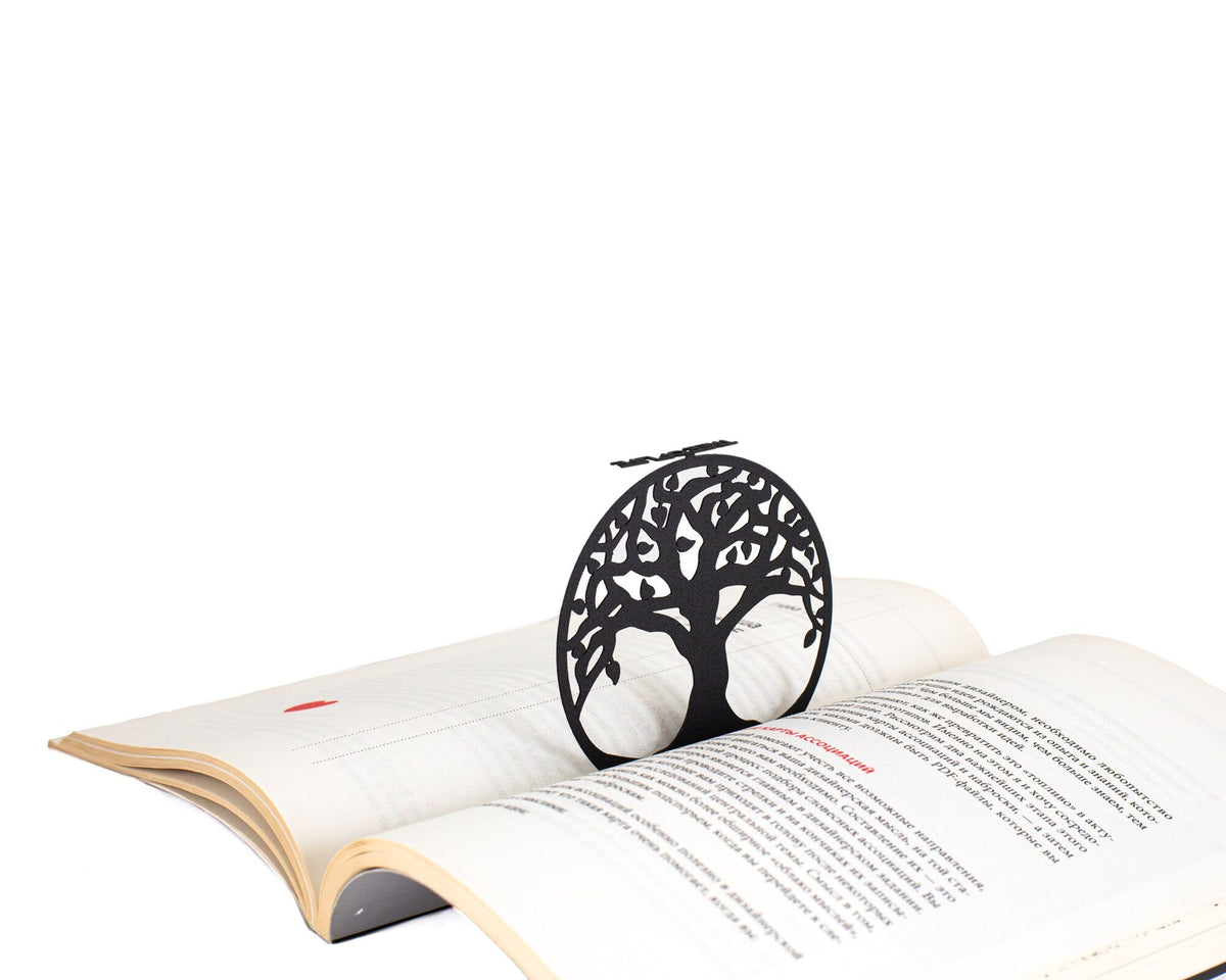 Tree of Life metal bookmark lying across the pages of an open book