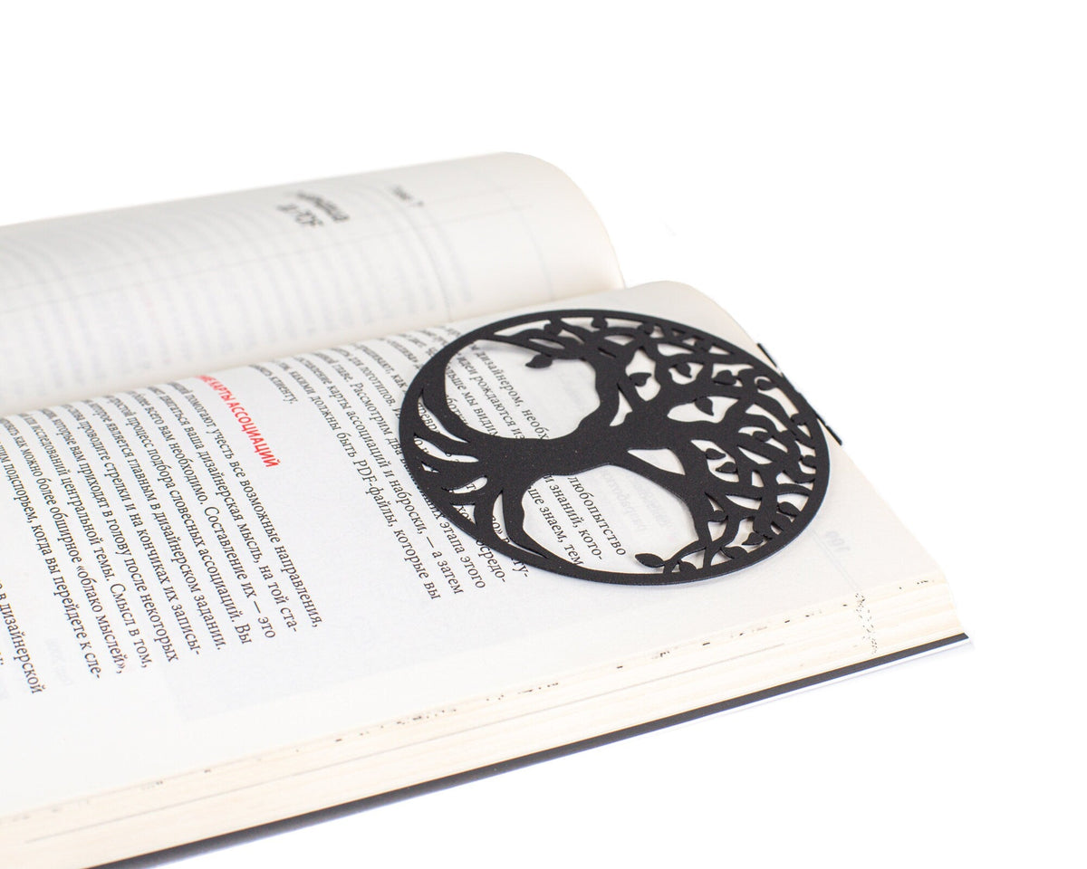 Tree of Life metal bookmark marking a page in an open book