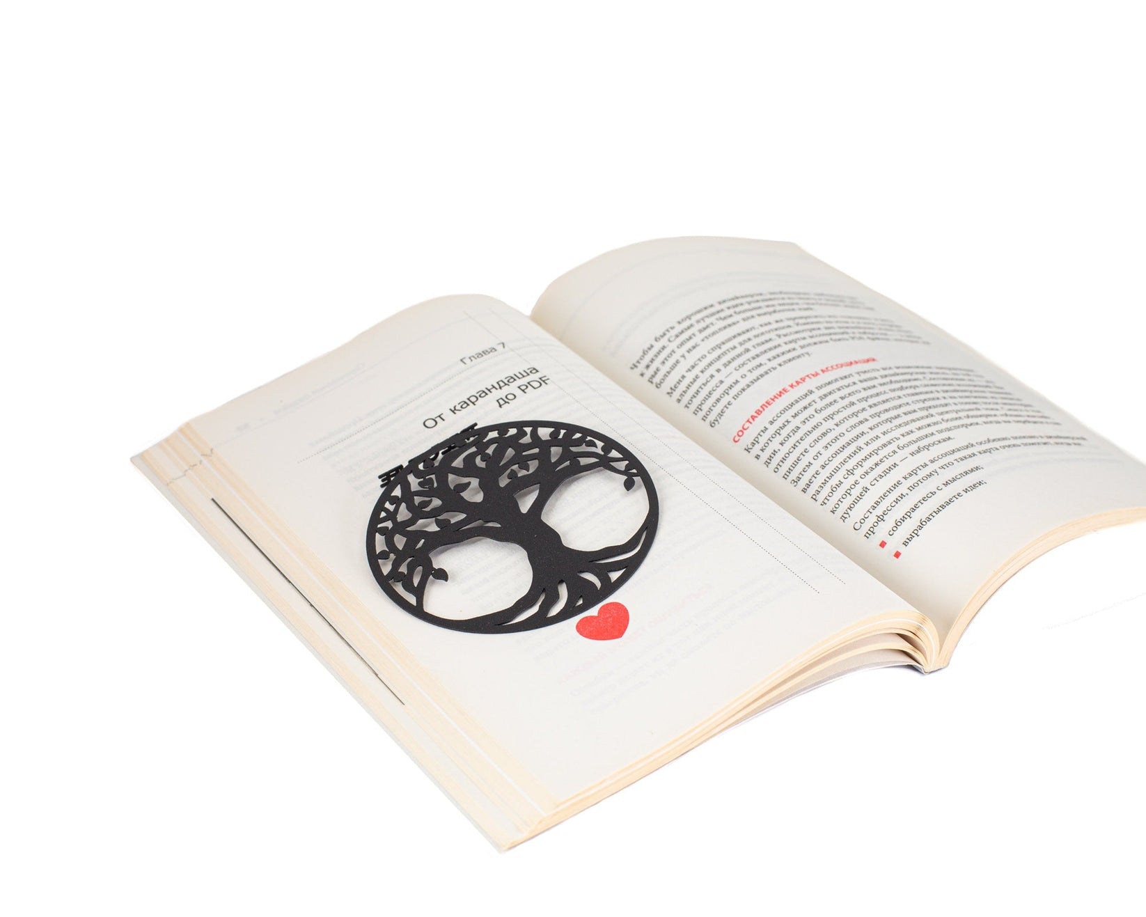 Tree of Life metal bookmark set into the gutter of an open book