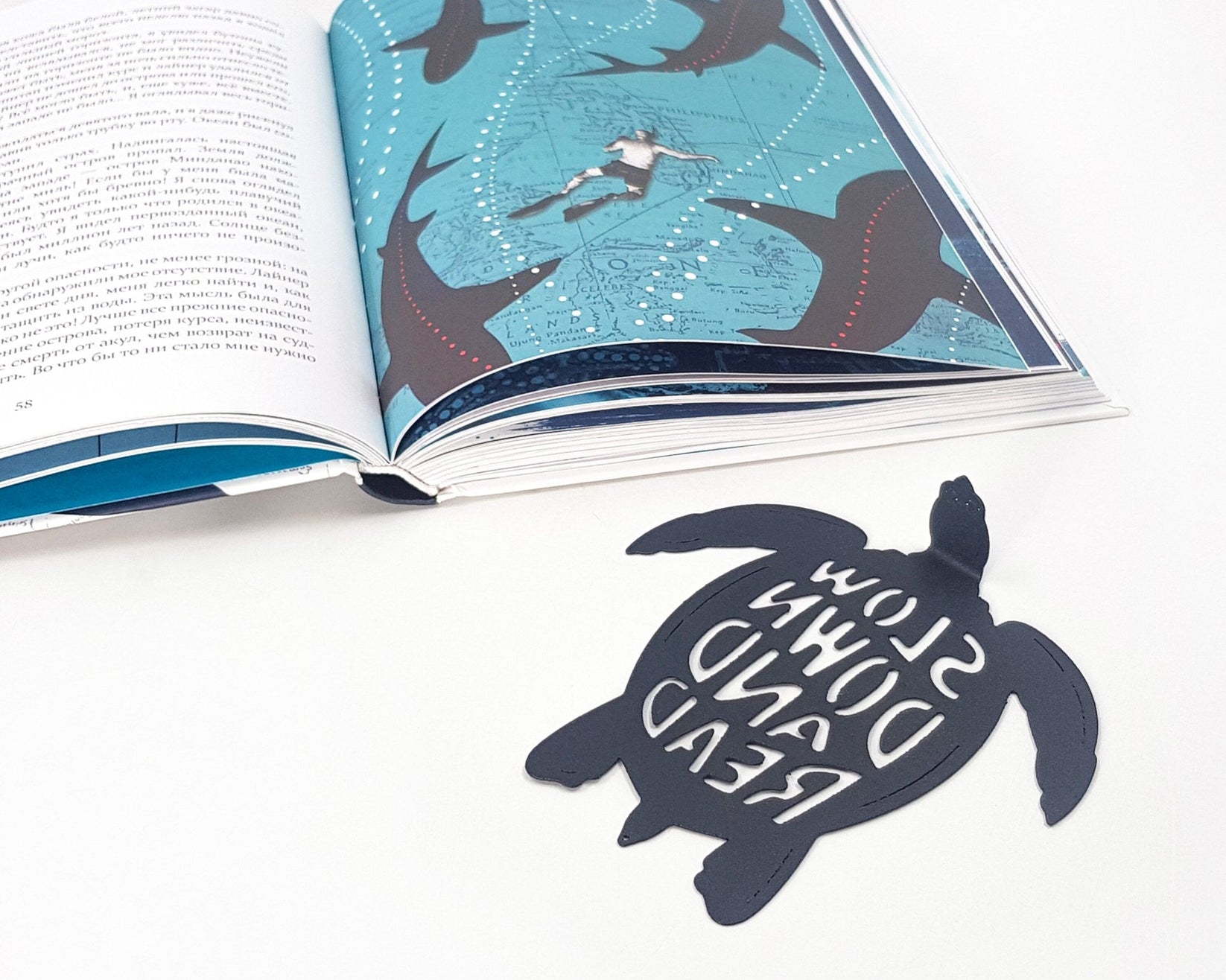Turtle metal bookmark placed on a colour illustration