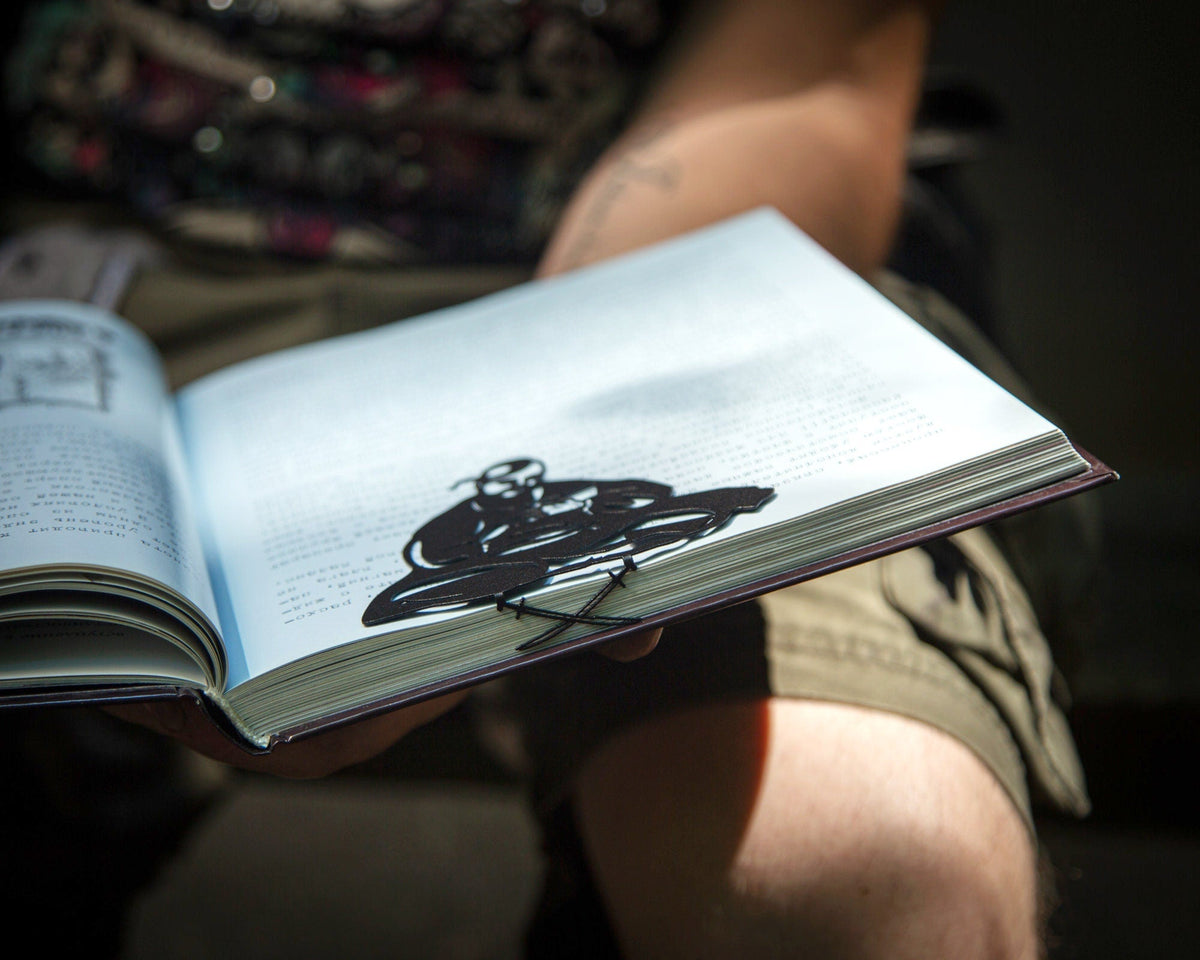 Ukrainian Kozak metal bookmark held up beside an open book