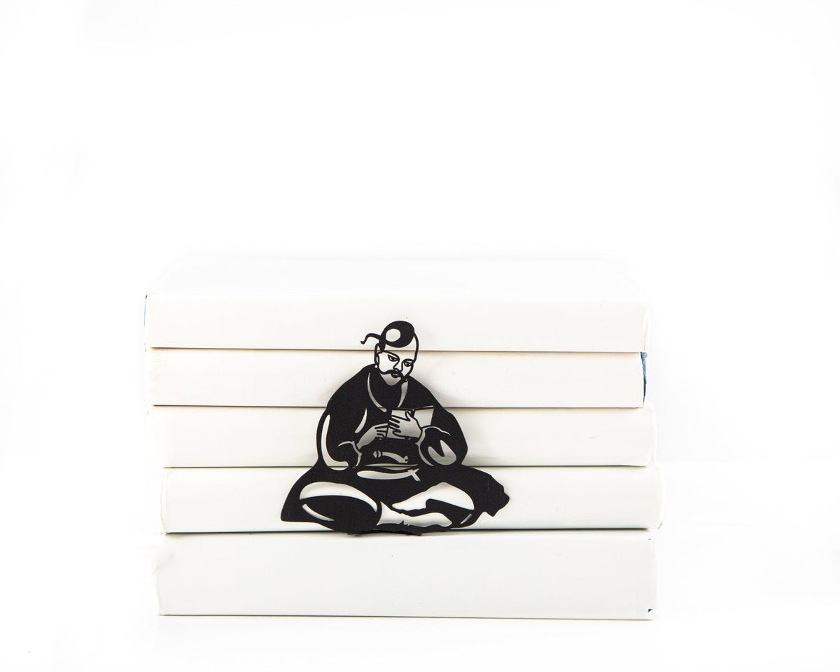 Ukrainian Kozak metal bookmark in a closed book, only its top showing above the pages
