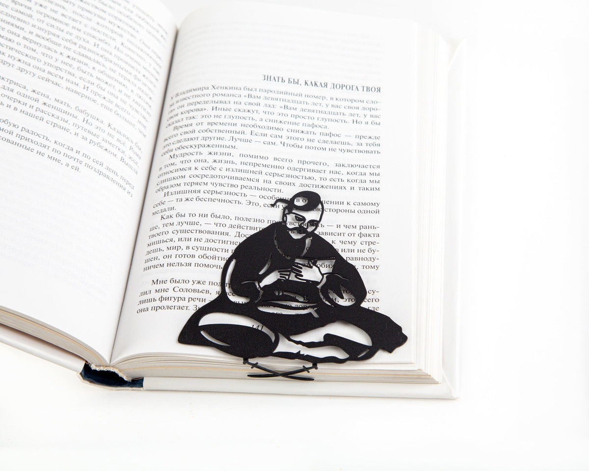Ukrainian Kozak metal bookmark marking a page in an open book