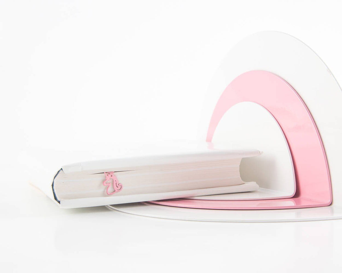 Unicorn metal bookmark in red in a closed book, only its top showing above the pages