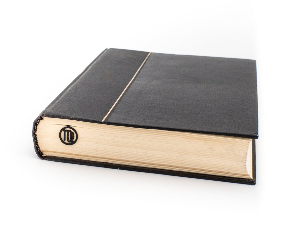 Virgo metal bookmark in a closed book, only its top showing above the pages