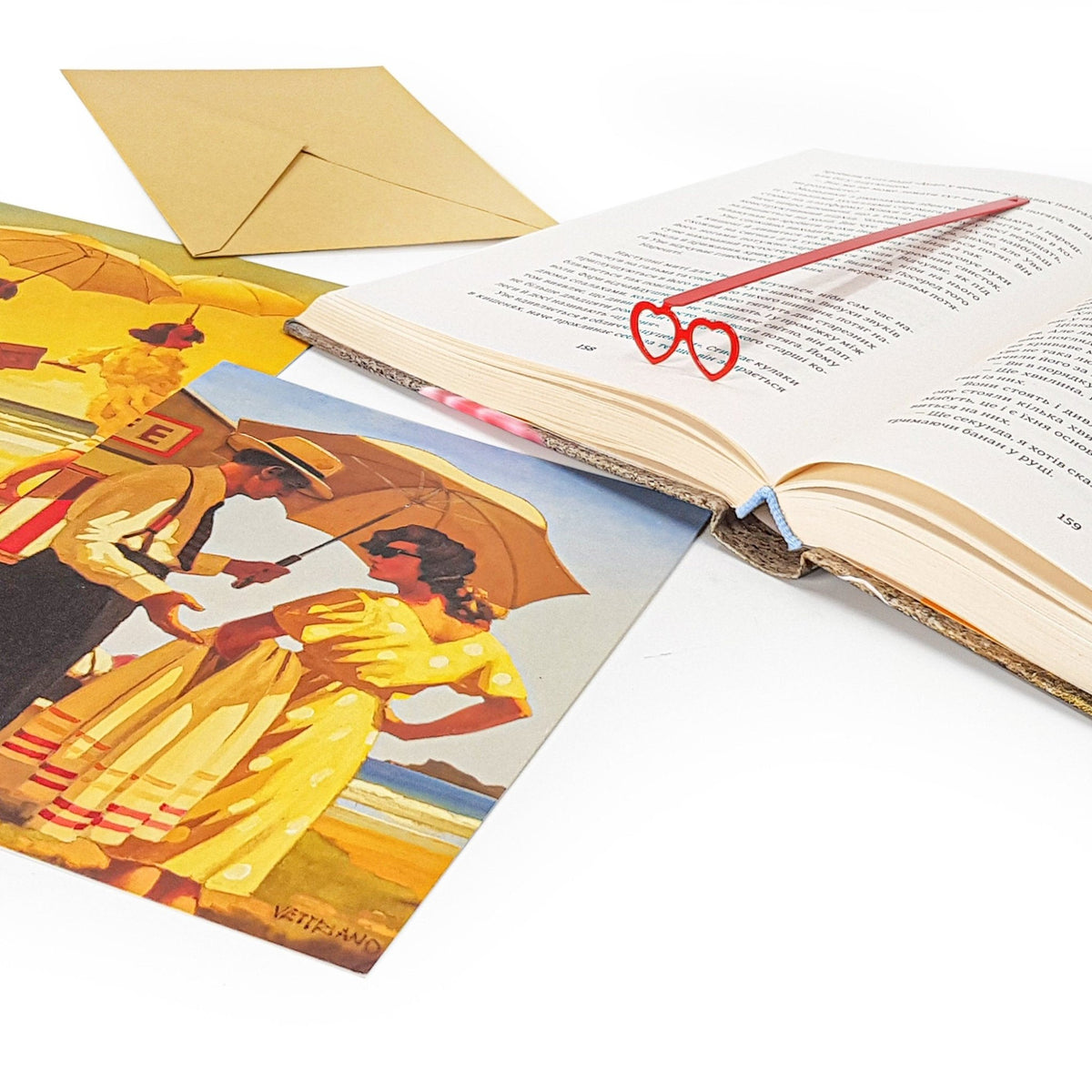 Vision Love metal bookmark in red marking a page in an illustrated book, view 4