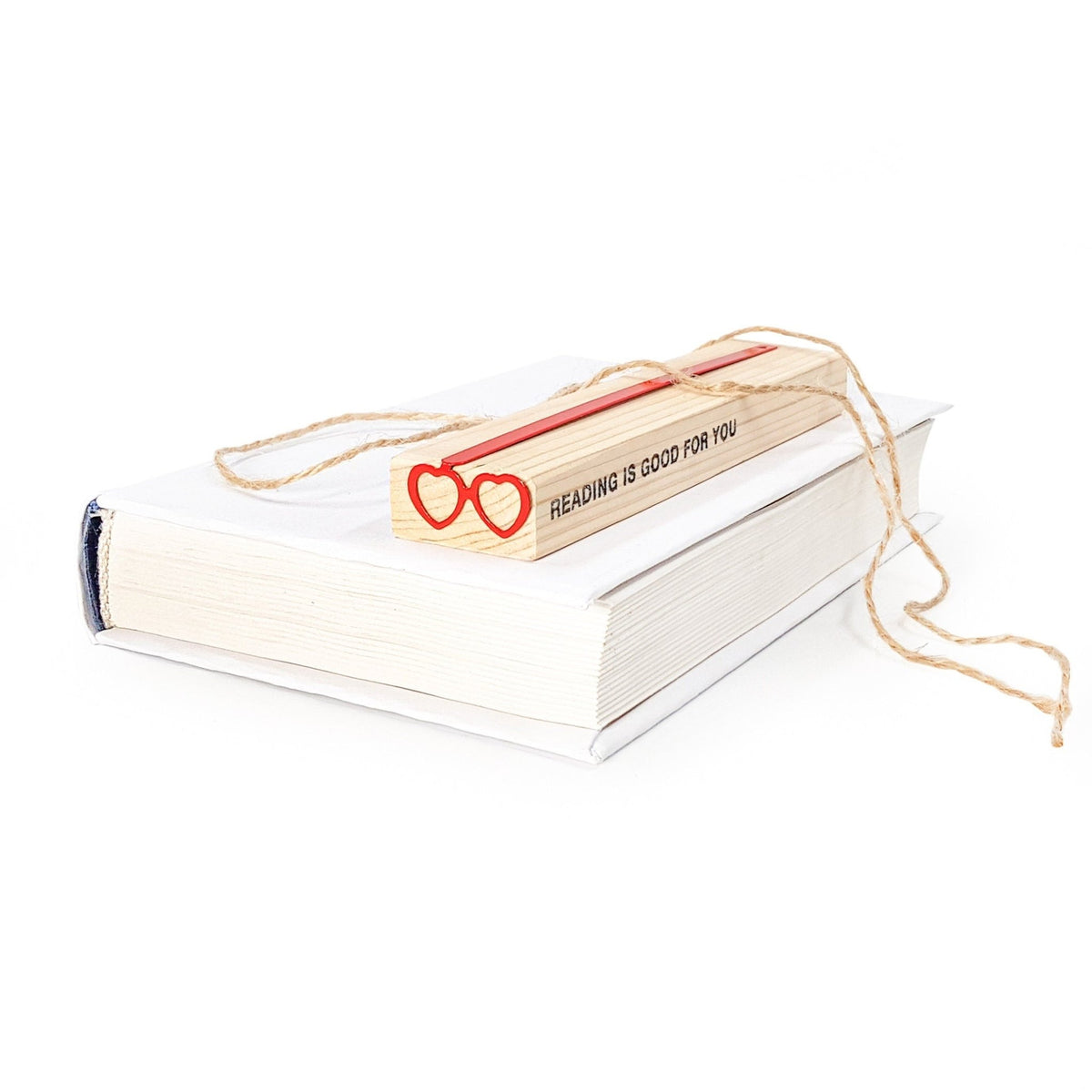 Vision Love metal bookmark in red in a closed book, only its top showing above the pages