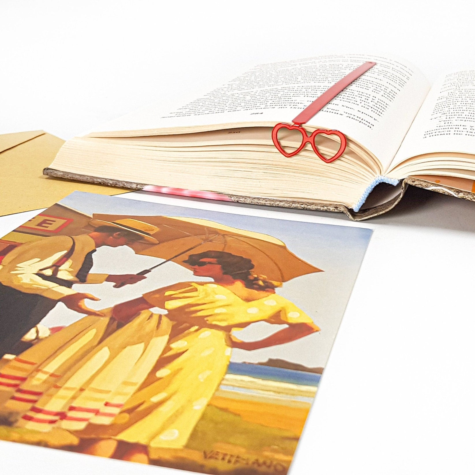 Vision Love metal bookmark in red on an illustrated page