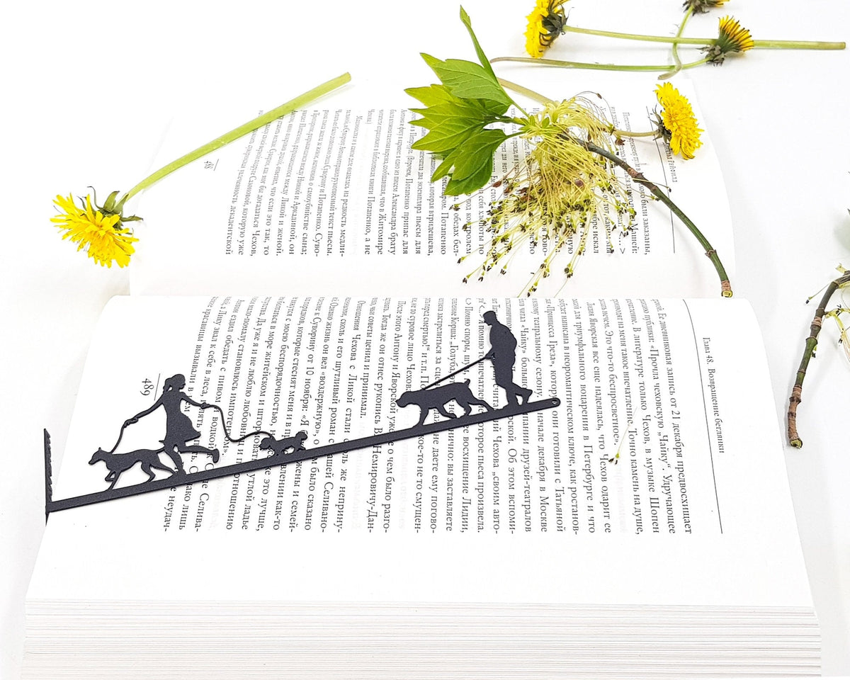 Walking the Dog metal bookmark marking a page in an open book