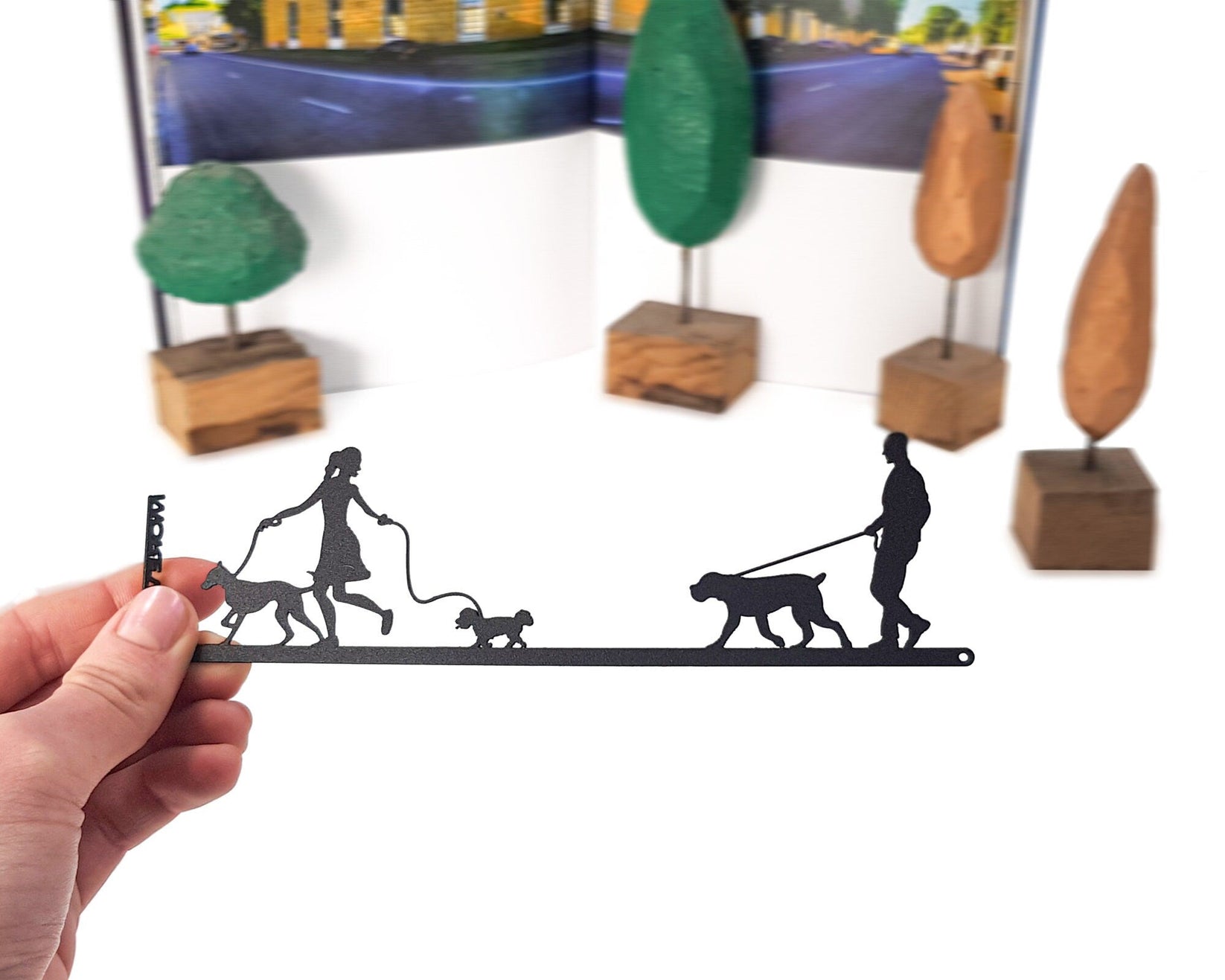 Walking the Dog metal bookmark held in a hand above an open book