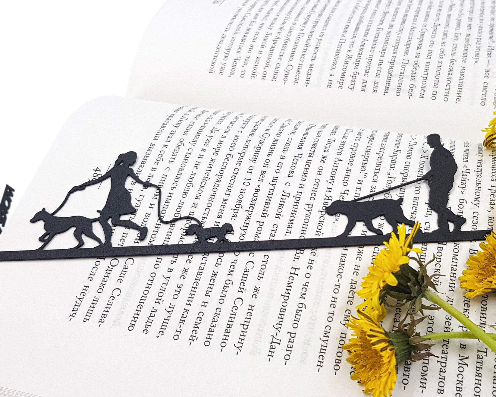 Walking the Dog metal bookmark resting on the pages of an open book