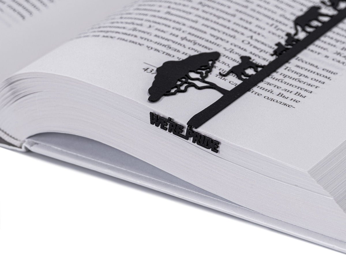 We're a Pride metal bookmark resting on the pages of an open book