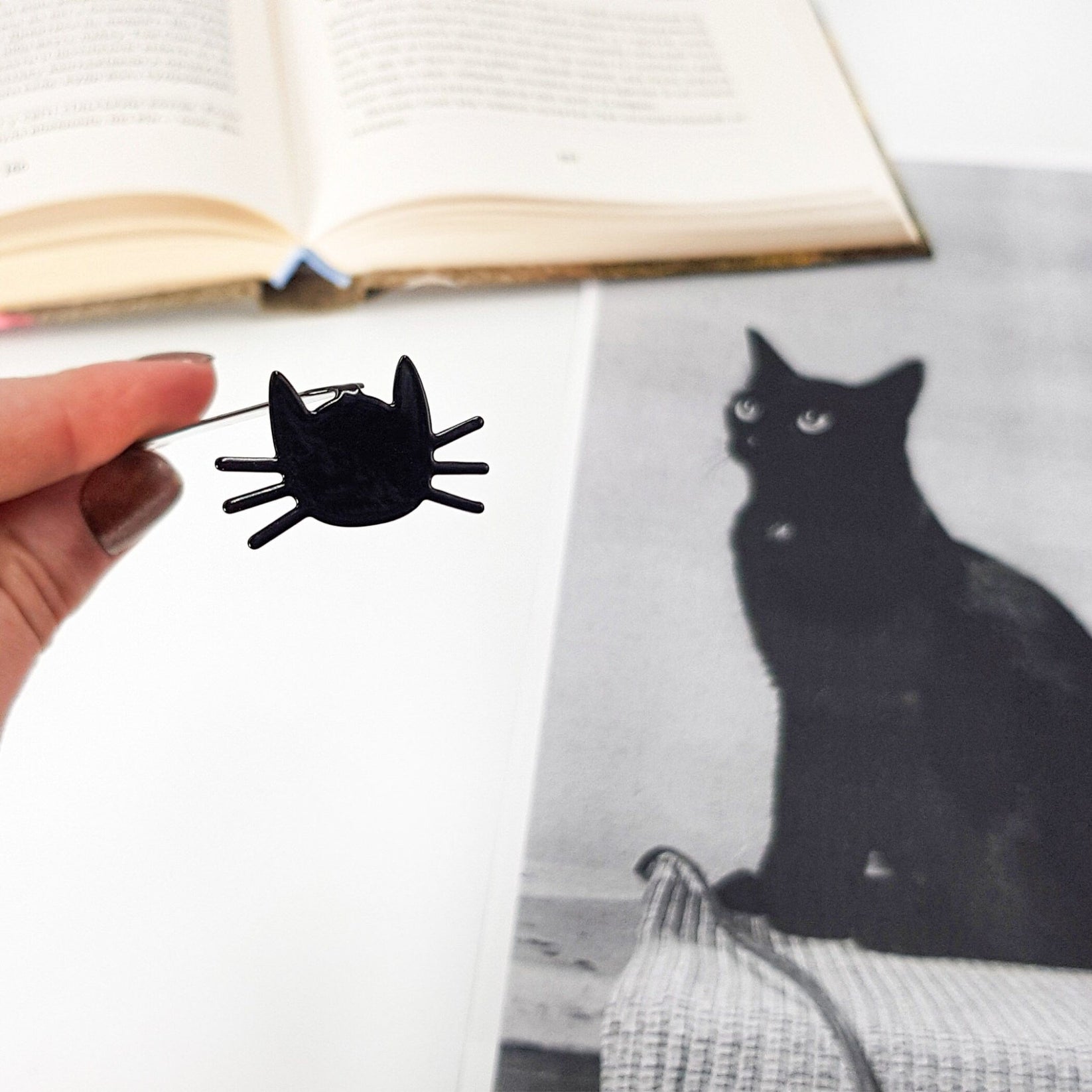 Whiskers in Your Book metal bookmark placed on a colour illustration