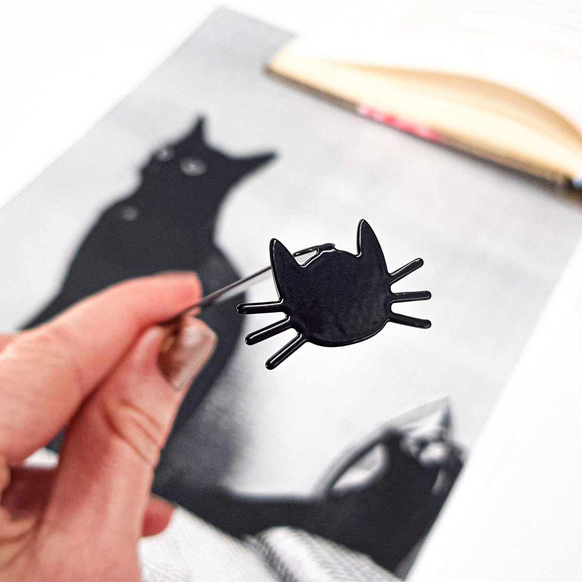 Whiskers in Your Book metal bookmark marking a page in an illustrated book