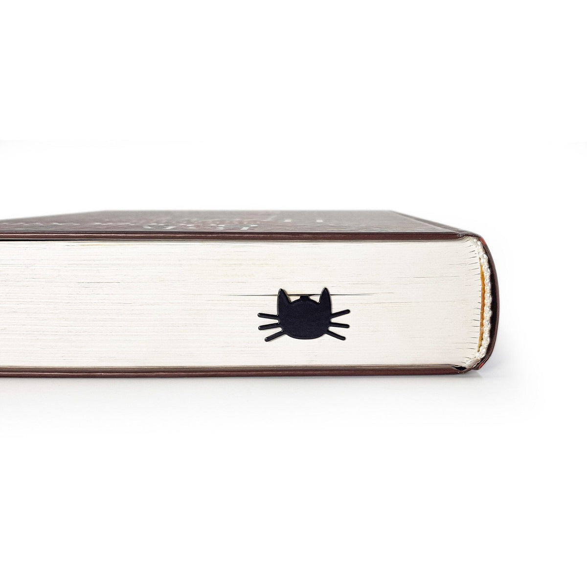Whiskers in Your Book metal bookmark in a closed book, only its top showing above the pages