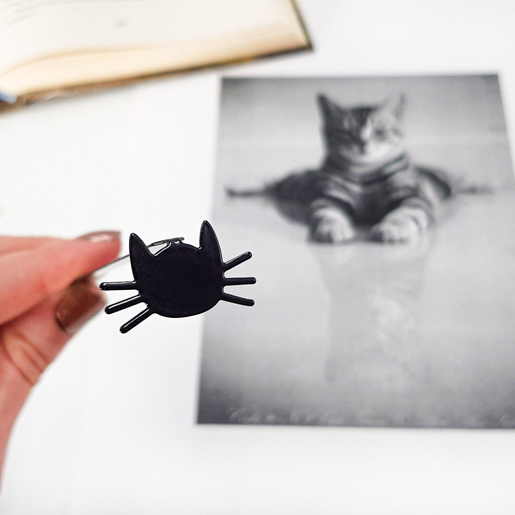 Whiskers in Your Book metal bookmark on an illustrated page