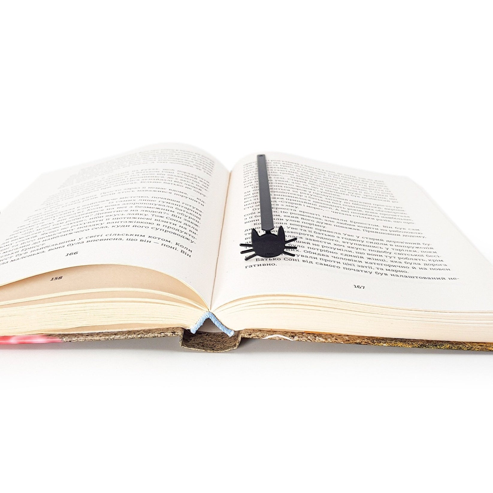 Whiskers in Your Book metal bookmark resting on the pages of an open book