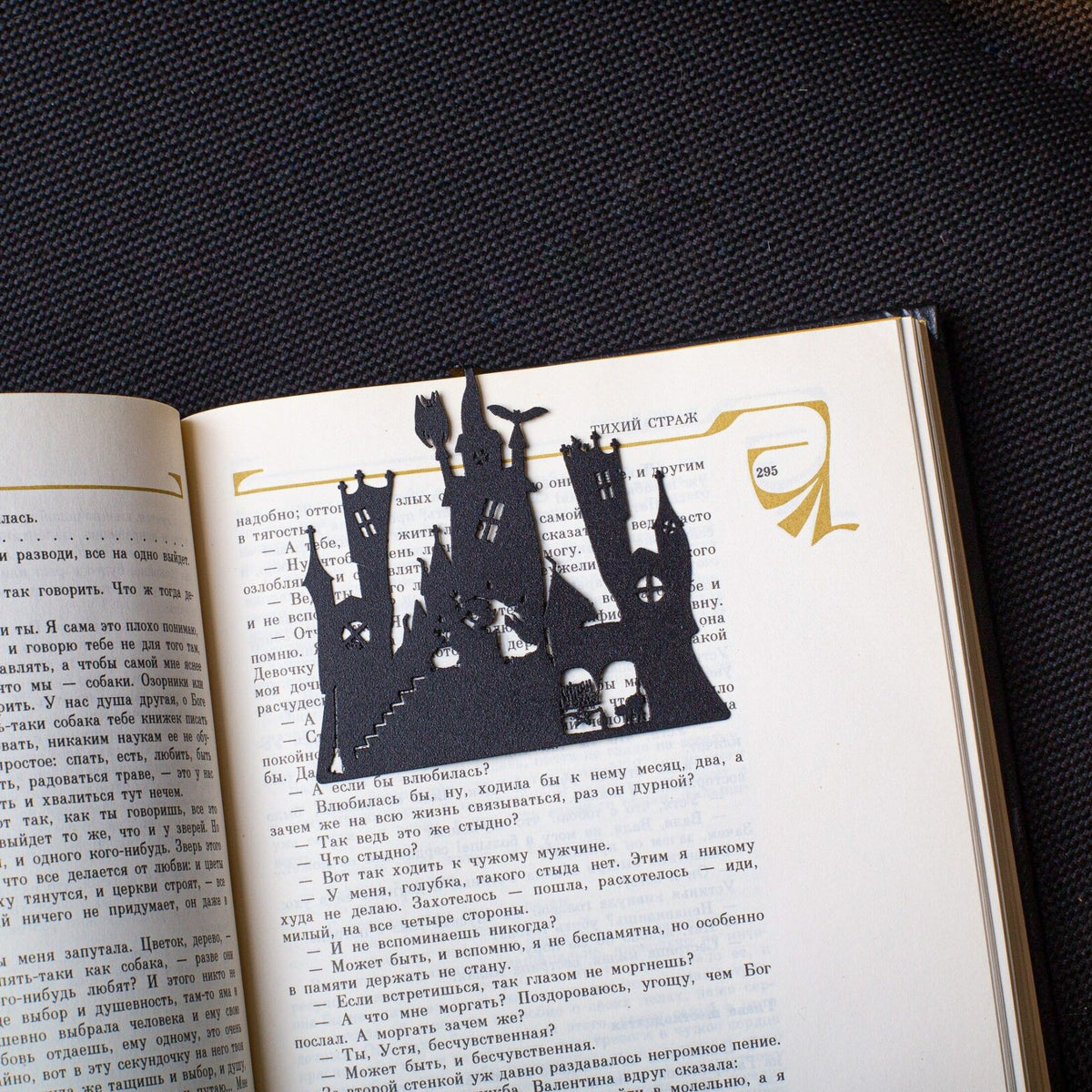 Witch's Castle metal bookmark marking a page in an open book