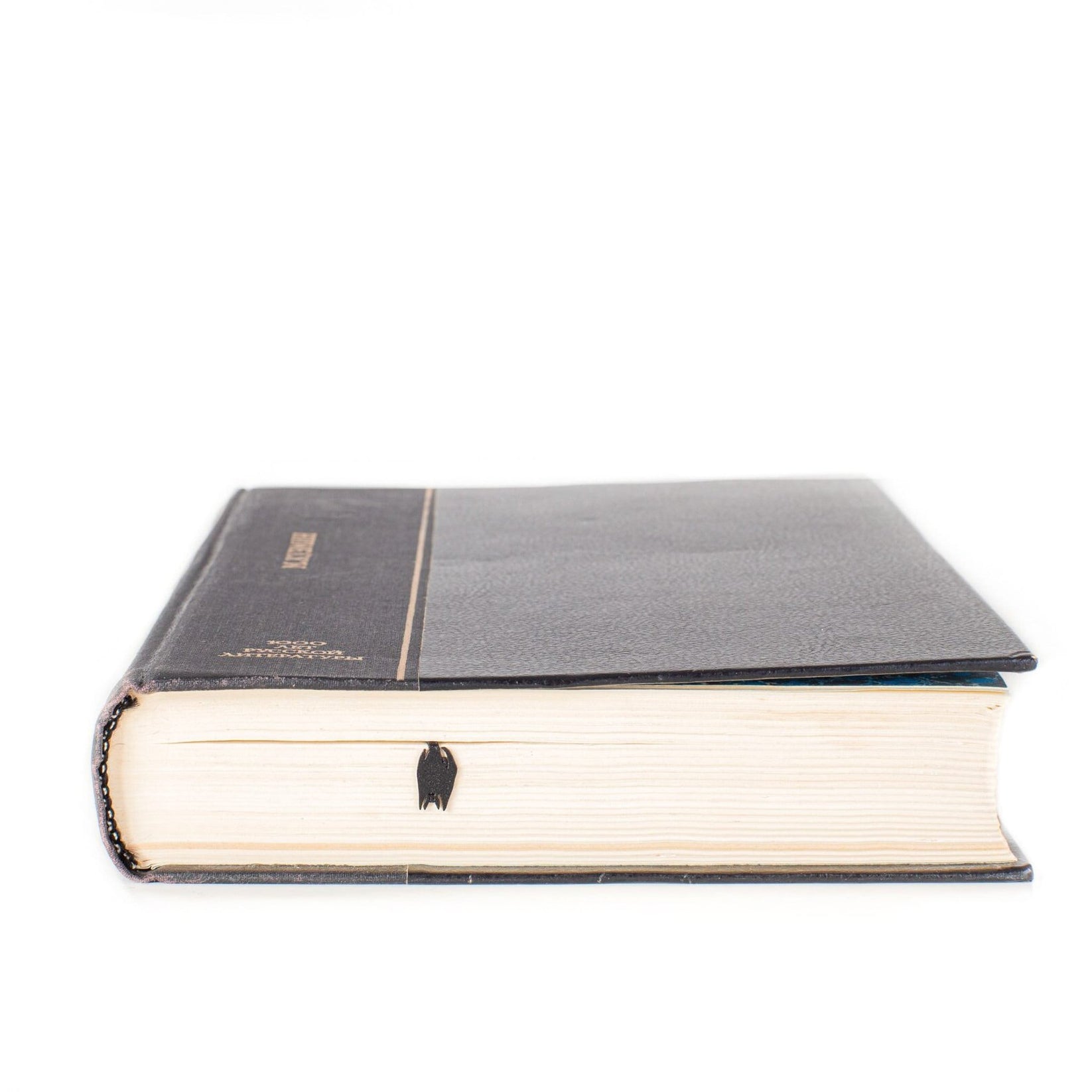 Witch's Castle metal bookmark in a closed book, only its top showing above the pages