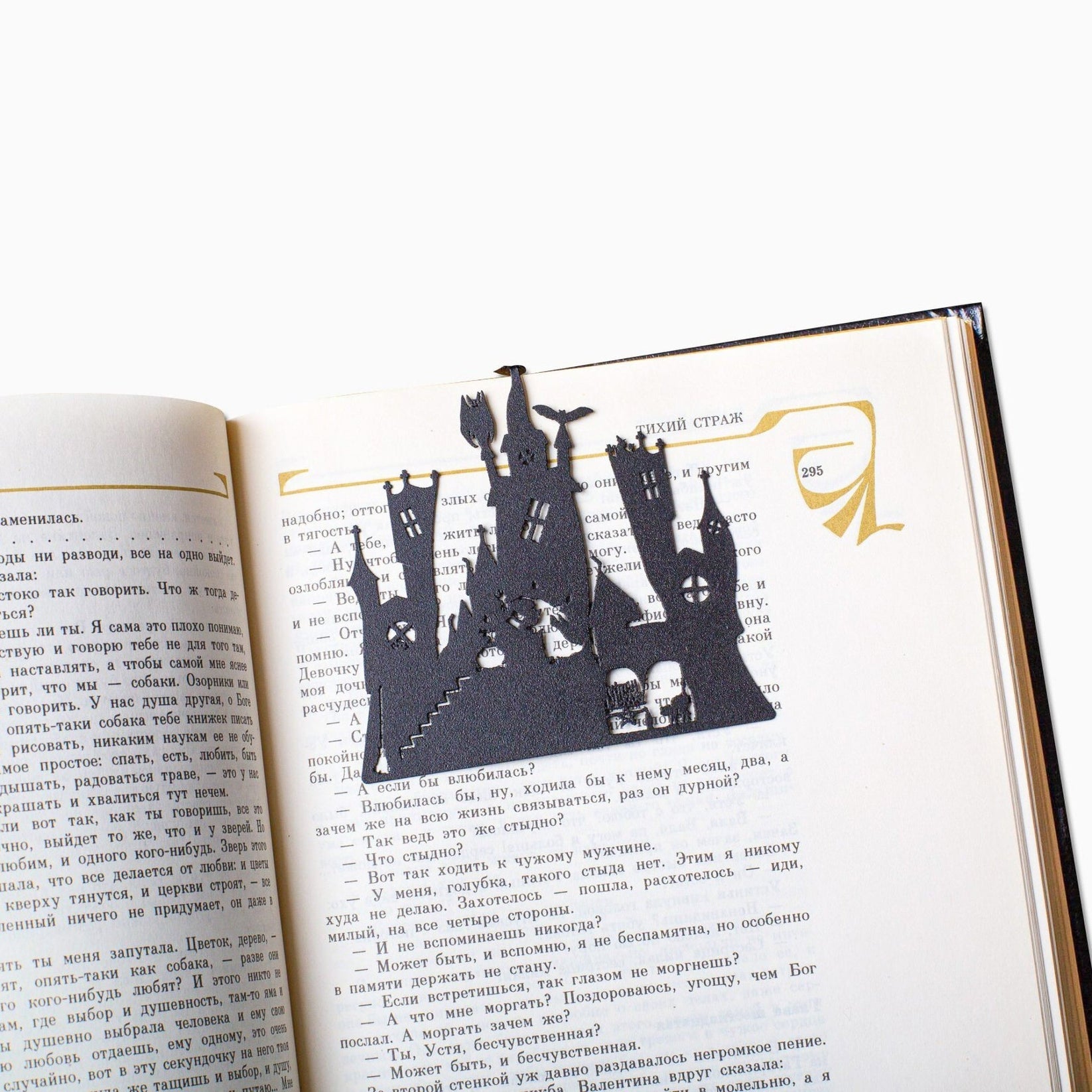 Witch's Castle metal bookmark resting on the pages of an open book
